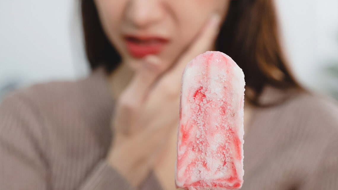 chica que sufre de sensibilidad dental al comer un helado